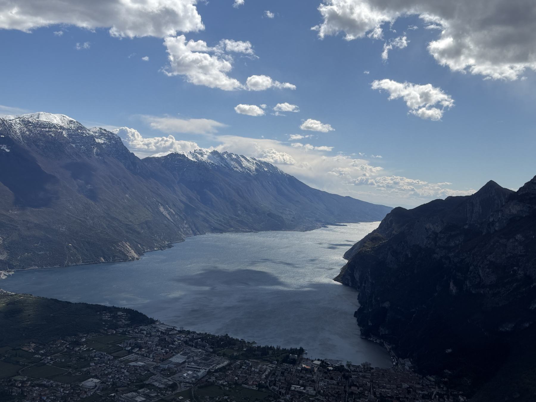 A lake seen from altitude, snow-covered peaks beyond
